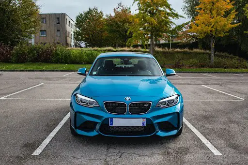 Un auto azul estacionado en un estacionamiento al aire libre.