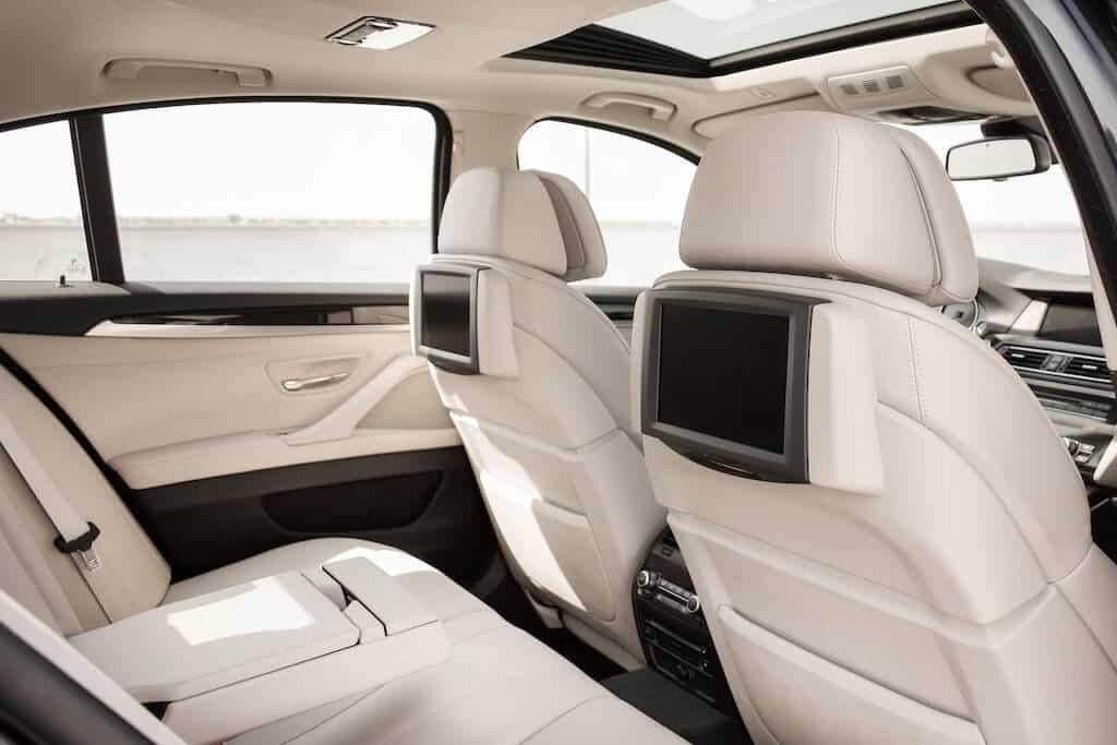 Pequeñas pantallas de televisión en los respaldos de los asientos delanteros de un automóvil.