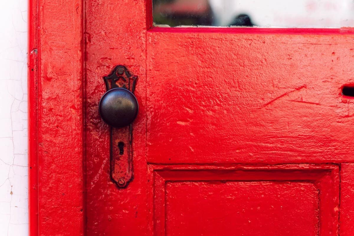Cerradura simple y pomo de una puerta roja.
