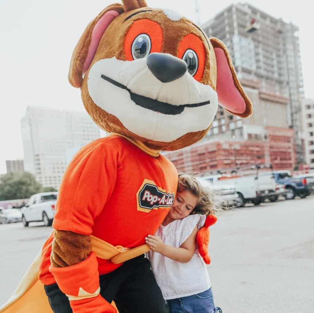 Mascota de Pop-A-Lock abrazando a un niño
