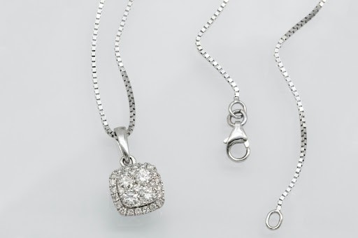 Un collar de diamantes sobre un fondo gris claro. 